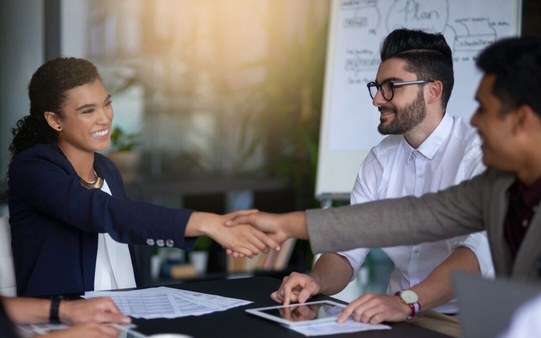 Smiling businesswoman shaking hands with a client post-sale.