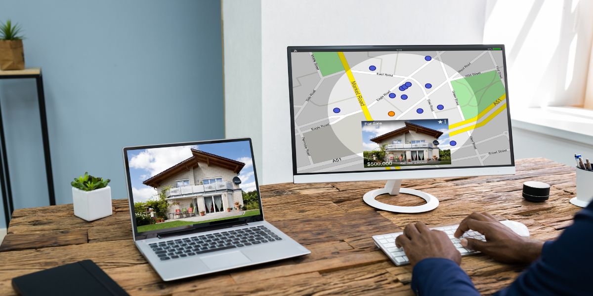 Person using a computer with a dual monitor setup displaying a house listing and map location.